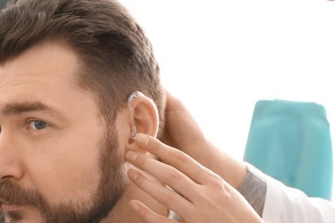 A Doctor or Audiologist Wearing Hearing Aid To Her Patient.