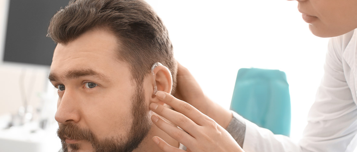 A Doctor or Audiologist Wearing Hearing Aid To Her Patient.