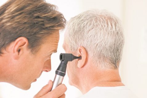 An Audiologist Examining An Old Man Ear With Otoscope.