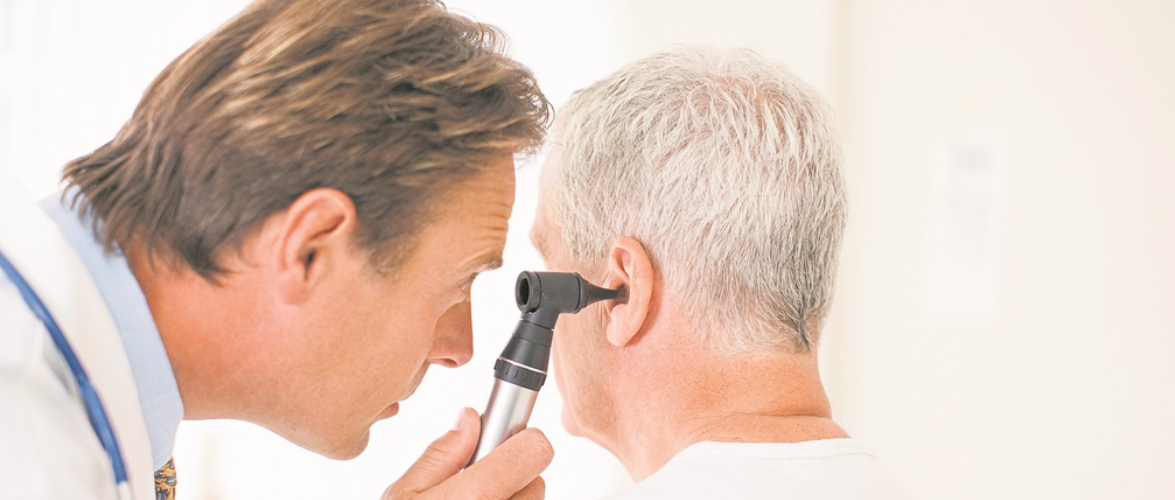 An Audiologist Examining An Old Man Ear With Otoscope.