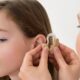 A Doctor Putting Hearing Aid In The Ear of A Girl.