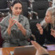 An instructor and trainees communicating in sign language sitting in a training room.